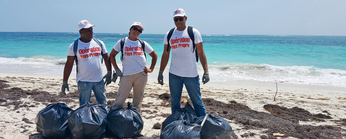 Bénévoles de l'association Entreprises et environnement avec des sacs poubelles pour l'opération pays propre sur une plage 